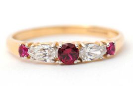 A 14ct ruby and diamond ring, with central round ruby and pear shape diamond to either side and a