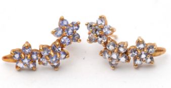 A pair of 9ct tanzanite cluster earrings, comprised of a curve of three clusters of small round
