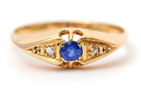 An 18ct sapphire and diamond ring, with central round sapphire with a diamond highlight to either