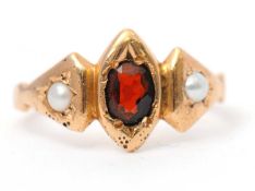 A 15ct garnet and split pearl ring, with central oval garnet in marquise rubover mount, and a
