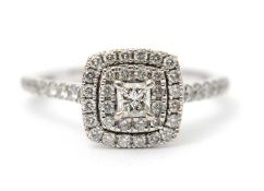 An 18ct diamond halo ring, the central princess cut diamond surrounded by two halos of round