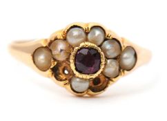A garnet and seed pearl ring, the central garnet surrounded by seed pearls, with tapered shoulders