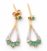 A pair of 9ct emerald and diamond earrings, the pear shape drops with three small round emeralds and