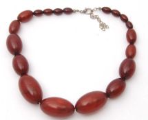 A bakelite faux 'cherry' amber bead necklace, with oval beads between 7.6 - 21.2mm diameter, 39cm