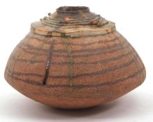 A Studio Pottery vase of ovoid form with a brown circular design, overlaid with green slip, width