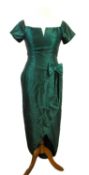 A green satin cocktail dress, with short sleeves, fitted waist with bow detail, and tulip style