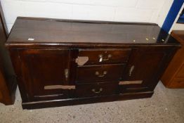 An 18th Century oak dresser base with three central drawers and two panelled doors set on a plinth