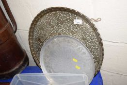 A brass serving tray with embossed decoration and one other