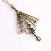 An Edwardian yellow metal green peridot and seed pearl set open work pendant, unmarked but tests