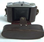Agfa Isolette II Klappkamera mit braunem Lederetui. Mittelformat Sucherkamera aus den 1950er Jahren.