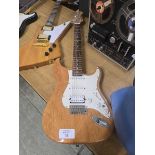 +VAT An Aria STG-Series electric guitar in natural wood finish