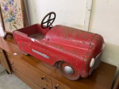 A mid-20th century tin plate pedal car