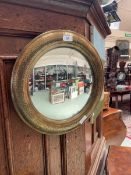 A brass effect framed circular convex wall mirror