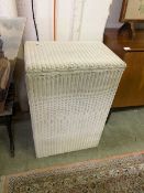A white painted Lloyd Loom laundry basket
