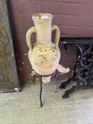 A terra cotta amphora on metalwork stand
