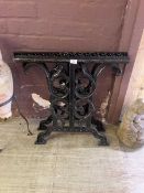 A pair of ornate black metal table ends