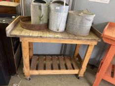 A distressed pine garage table on casters