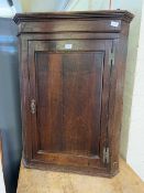 A late Victorian wall mounted oak corner cabinet
