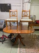 A yew veneered oval topped drop leaf dining table along with two lyre back chairs