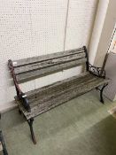 A weathered ornate metalwork frame garden bench