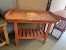 A pink painted weathered garage table with slatted undertier