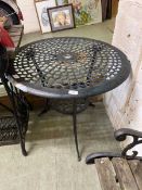 A weathered black painted aluminium garden table