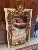 An ornate gilt framed wall mirror with rectangular surround