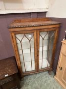 A 20th century mahogany effect display cabinet on ball and claw feet