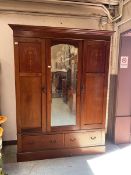 A late Victorian mahogany and strung wardrobe, central mirrored panel flanked by two doors with