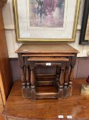 An oak nest of three occasional tables on turned supports