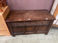 A 20th century oak coffer with foliate carving to front