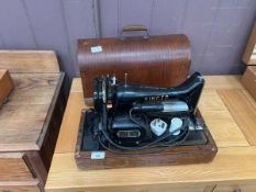 A cased Singer electric sewing machine
