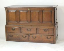 An 18th century oak two-section mule chest, the lift lid revealing a vacant interior over five