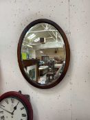 Bevelled and oak framed glass mirror