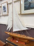 A hand crafted model of a sailing boat on stand