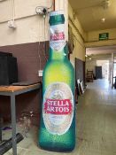 An oversized advertising sign in the form of a bottle of Stella Artois