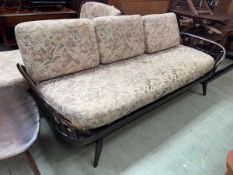 A dark Ercol surfboard sofa There is a small split to right arm and lots of scuffing to both arms