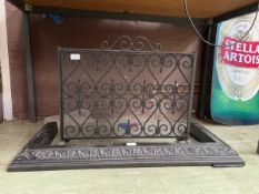 A black cast metal fire grate along with an embossed black metal fire fender