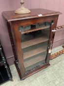 An antique lockable stained wood cupboard With glazed door containing shelving