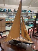 A scratch built model of a sailing boat on stand.
