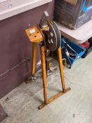 A weathered yellow metalwork pipe bender on stand