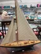 A scratch built model of a sailing boat on stand.