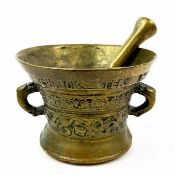 A 17TH CENTURY BRONZE MORTAR AND PESTLE.