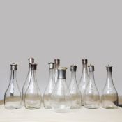 A COLLECTION OF TEN SILVER-PLATED CAPPED DECANTERS. (10).