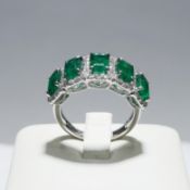 A PLATINUM EMERALD AND DIAMOND CLUSTER RING.