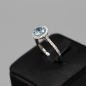 A 9CT WHITE GOLD AQUAMARINE AND DIAMOND CLUSTER RING.