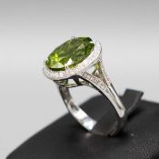 AN 18CT WHITE GOLD PERIDOT AND DIAMOND CLUSTER RING.