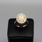 A 9CT GOLD OPAL AND DIAMOND CLUSTER RING.