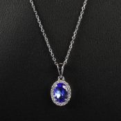 AN 18CT WHITE GOLD TANZANITE AND DIAMOND PENDANT NECKLACE.