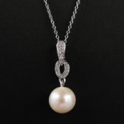 A 9CT WHITE GOLD ART DECO STYLE PENDANT.